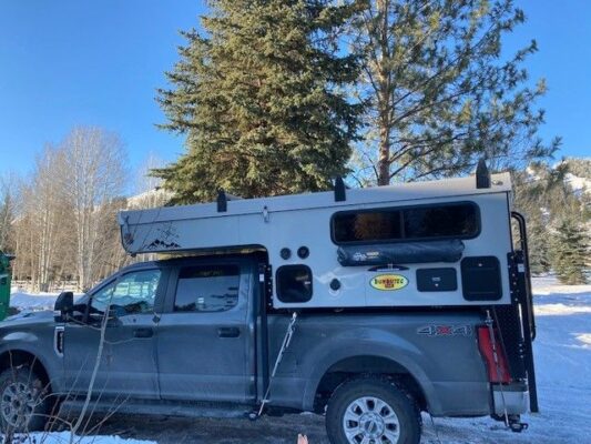 A truck with a camper on top of it.