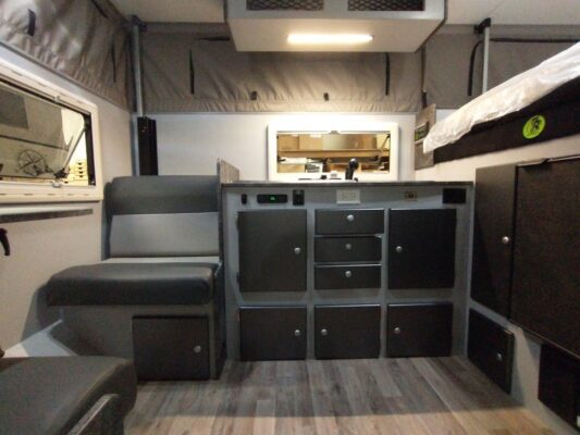 The interior of an rv with a bed and a desk.