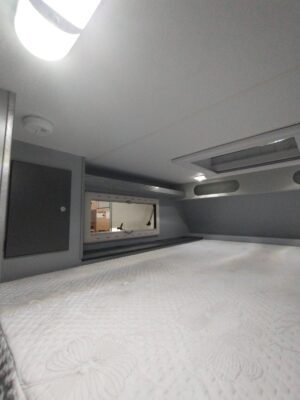 The inside of a camper with a bed in it.