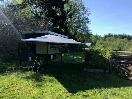 A camper is set up in a grassy area.