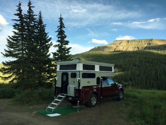 A camper truck with a tent on top of it.