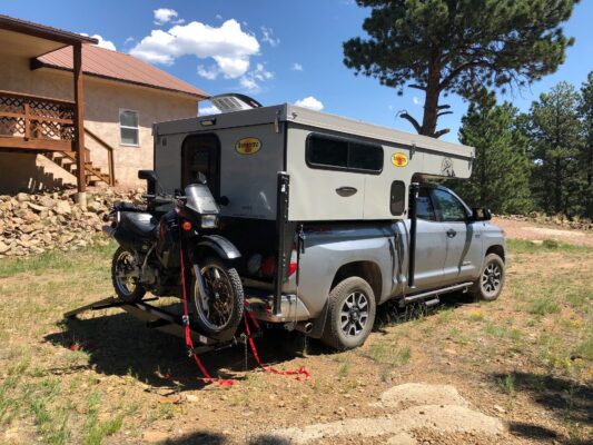 A toyota pickup truck with a camper attached to it.