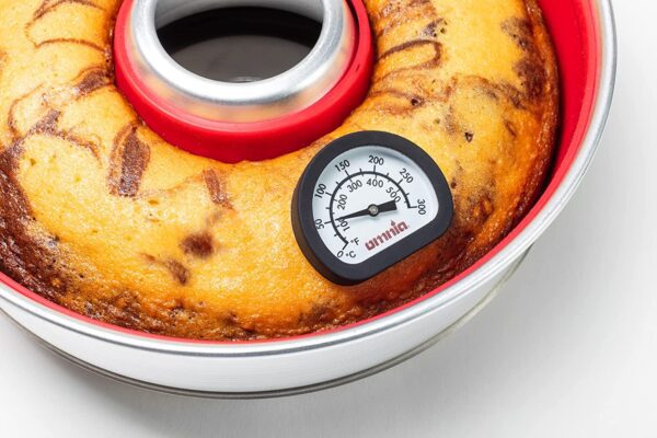 A cake in a tin with a Thermometer in it.