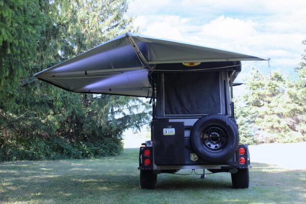 A jeep wrangler with an awning attached to it.