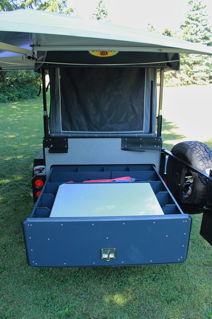 The back of a camper with a laptop in it.