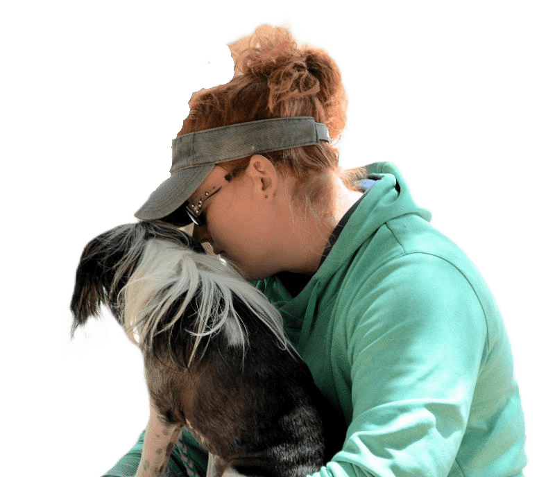 Woman in green hoodie hugging a dog.