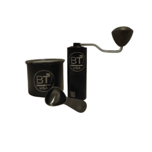 Black hand crank coffee grinder with scoop.