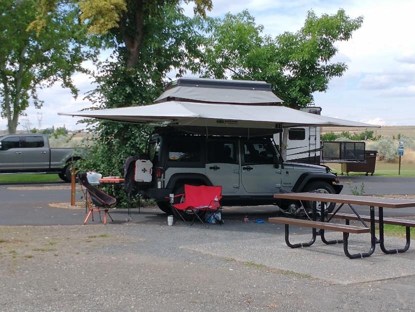 Camper van parked at campsite with picnic table.