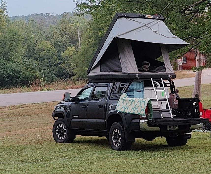 Black truck with rooftop tent camping.