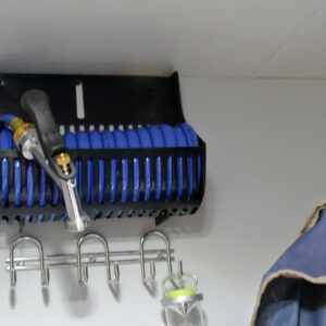 Blue hose and nozzle on a wall rack.