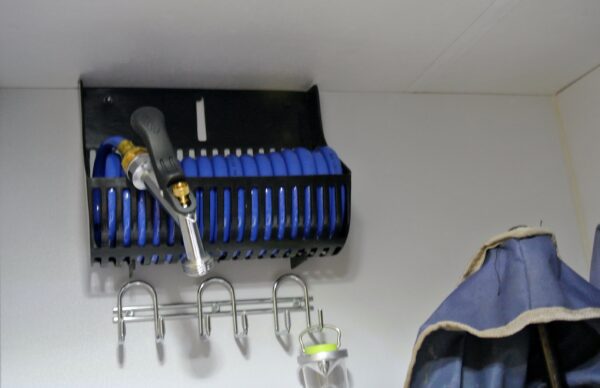 Blue hose and nozzle on a wall rack.