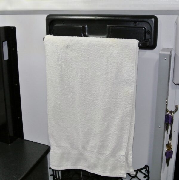 White towel hanging on a rack in a bathroom.