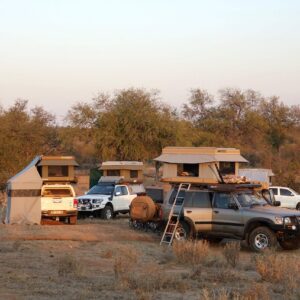 Campsite with multiple cars and tents.