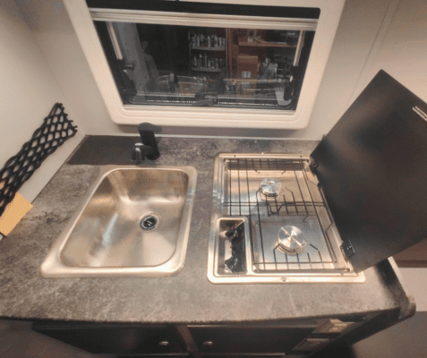 A sink and oven in an rv kitchen.