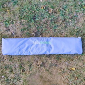 A blue bag laying on the ground in grass.