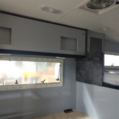 Interior of a camper with storage cabinets.