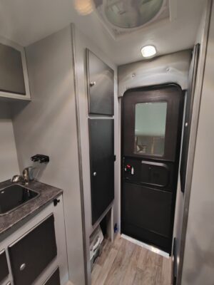 Camper interior with kitchenette and door.