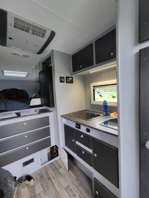 Compact camper van interior with kitchenette.