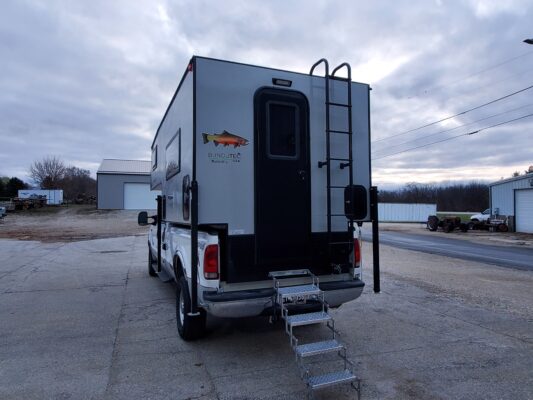Camper van with rear ladder and stairs.